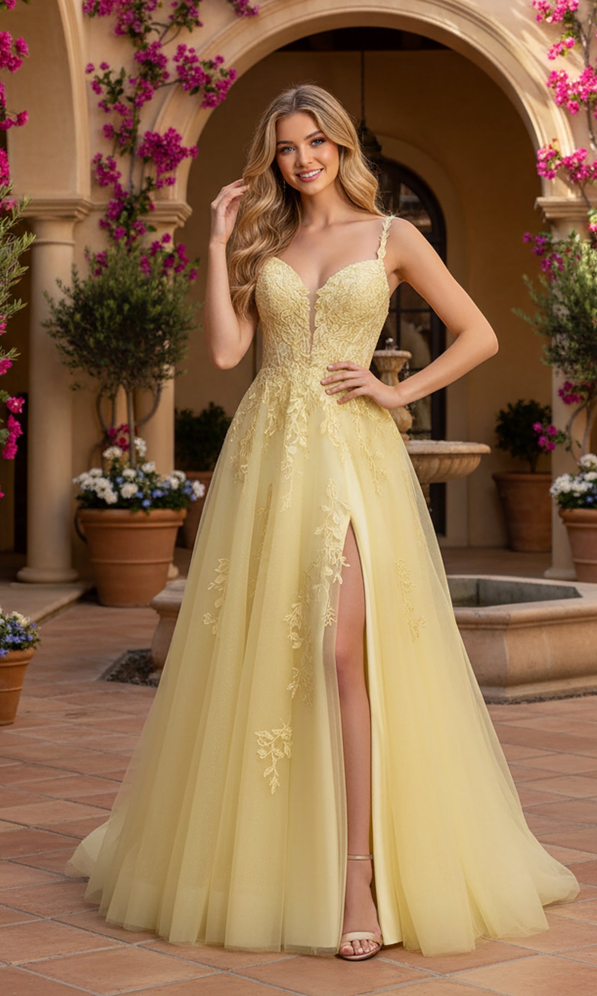 A woman stands outdoors in front of a courtyard filled with potted plants, wearing the yellow Long Prom Dress: PromGirl Exclusive 250261, featuring an A-line silhouette, floral embroidery, and a thigh-high slit.